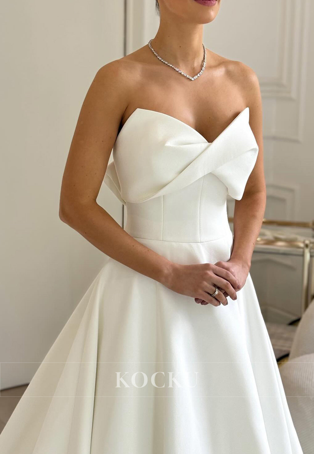 Timeless White Satin Wedding Gown with Bow Embellishment and Full Skirt