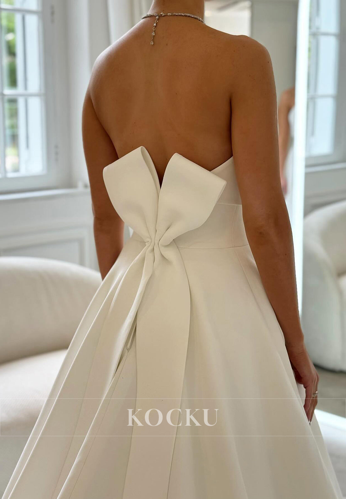 Timeless White Satin Wedding Gown with Bow Embellishment and Full Skirt
